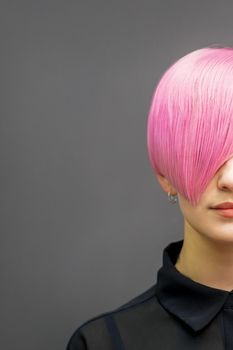 Portrait of a beautiful young caucasian woman with short bright pink hair. Professional hair coloring