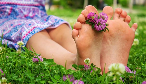 Children's feet with a pattern of paints smile on the green grass. Selective focus. nature.