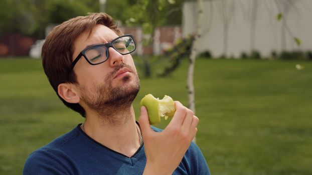 Employee Taking Break Work. Young man Eating a apple as snack. Heathy food Concept.