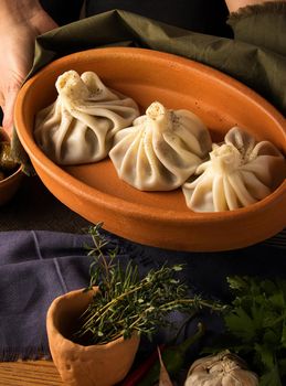 A vertical shot of a luxurious restaurant table with a gourmet khinkali dish