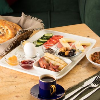 A closeup shot of a breakfast white plate and a cup of coffee on a wooden table