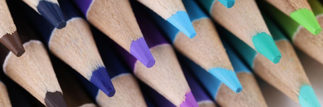 Close-up of sharpened pencils for drawing laying on each other forming stack. Pigmented crayons for painting on paper. Idea, vision, imagination concept