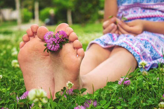 Children's feet with a pattern of paints smile on the green grass. Selective focus. nature.