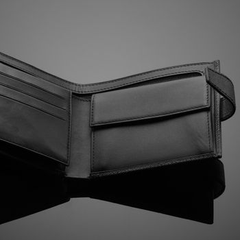 A closeup of a fashionable leather wallet on a dark background