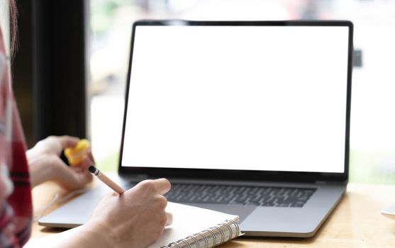 Young man working on his laptop with blank copy space screen for your advertising text message in office, Back view of business man hands busy using laptop at office desk.