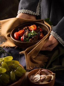 A vertical shot of a chef serving a gourmet salad dish