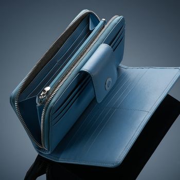 A closeup of a fashionable leather wallet on a dark background