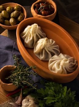 A vertical shot of a luxurious restaurant table with a gourmet khinkali dish