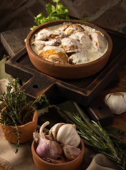 A vertical shot of a chicken covered in a creamy sauce