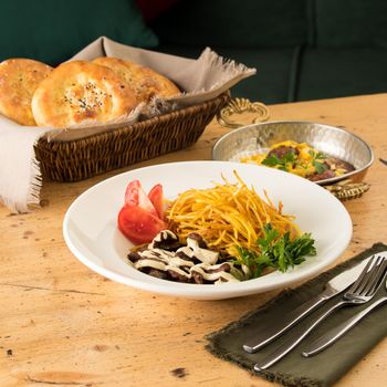 A closeup of a delicious dish with shredded potatoes, beef, sauce and sandwiches