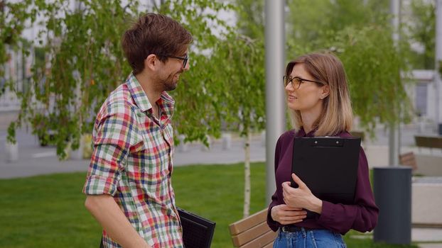 Two college students meeting and talking on campus, in a park. Exam period.Having serious conversation