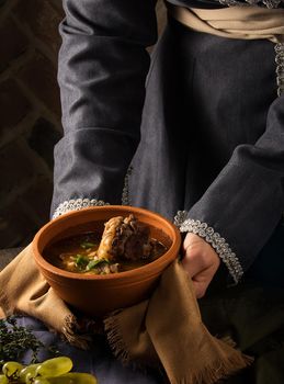 A vertical shot of a chef serving a gourmet dish