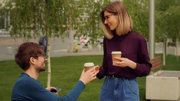 Smiling caucasian businesswoman and man Funny Coversation talking. Coworkers friendly discussion during lunch time. Friendly atmosphere outdoor.