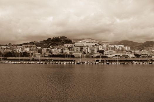 Genova, Italy- June 20,2022: Port of Porto Antico harbor with luxury  yachts and attractions, Bigo construction in historical centre of old european city Genoa with beautiful sunset reflection.