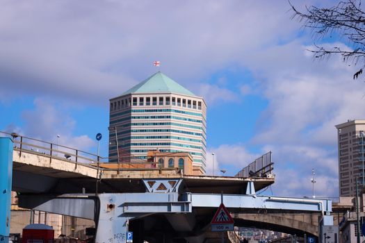 Genova, Italy-January 29, 2022: Beautiful modern high-rise buildings against the sky. 3d illustration on the theme of business success and technology. clouds reflection on the mirror.Industrial zone.