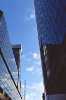 Genova, Italy-January 29, 2022: Beautiful modern high-rise buildings against the sky. 3d illustration on the theme of business success and technology. clouds reflection on the mirror.Industrial zone.