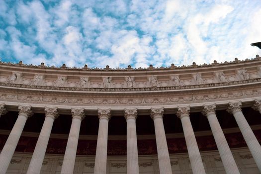 ROME, ITALY - February 05, 2022: Panoramic view around the Colosseum in city of Rome, Italy. Cold and gray sky in the background. Macro photography of the green parks with the old buildings.