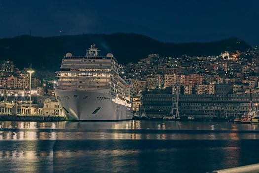 Genova, Italy- June 20,2022: Port of Porto Antico harbor with luxury  yachts and attractions, Bigo construction in historical centre of old european city Genoa with beautiful sunset reflection.