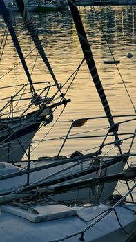 Genova, Italy- June 20,2022: Port of Porto Antico harbor with luxury  yachts and attractions, Bigo construction in historical centre of old european city Genoa with beautiful sunset reflection.