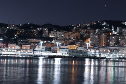 Genova, Italy- June 20,2022: Port of Porto Antico harbor with luxury  yachts and attractions, Bigo construction in historical centre of old european city Genoa with beautiful sunset reflection.