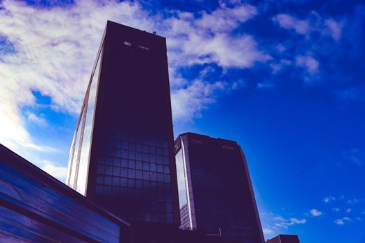 Genova, Italy-January 29, 2022: Beautiful modern high-rise buildings against the sky. 3d illustration on the theme of business success and technology. clouds reflection on the mirror.Industrial zone.