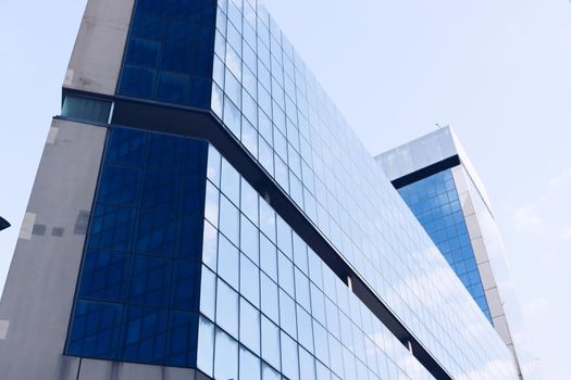 Genova, Italy-January 29, 2022: Beautiful modern high-rise buildings against the sky. 3d illustration on the theme of business success and technology. clouds reflection on the mirror.Industrial zone.