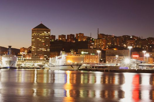 Genova, Italy- June 20,2022: Port of Porto Antico harbor with luxury yachts and attractions, Bigo construction in historical centre of old european city Genoa with beautiful sunset reflection.