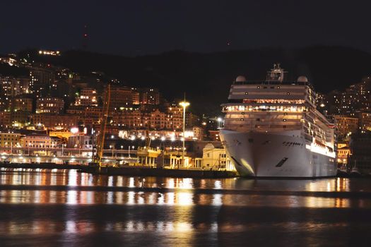 Genova, Italy- June 20,2022: Port of Porto Antico harbor with luxury yachts and attractions, Bigo construction in historical centre of old european city Genoa with beautiful sunset reflection.