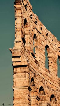 ROME, ITALY - February 05, 2022: Panoramic view around the Colosseum in city of Rome, Italy. Cold and gray sky in the background. Macro photography of the green parks with the old buildings.