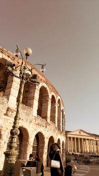 ROME, ITALY - February 05, 2022: Panoramic view around the Colosseum in city of Rome, Italy. Cold and gray sky in the background. Macro photography of the green parks with the old buildings.