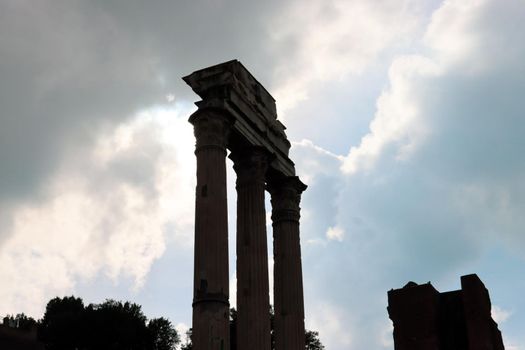 ROME, ITALY - February 05, 2022: Panoramic view around the Colosseum in city of Rome, Italy. Cold and gray sky in the background. Macro photography of the green parks with the old buildings.