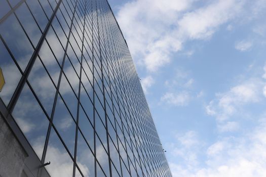 Genova, Italy-January 29, 2022: Beautiful modern high-rise buildings against the sky. 3d illustration on the theme of business success and technology. clouds reflection on the mirror.Industrial zone.