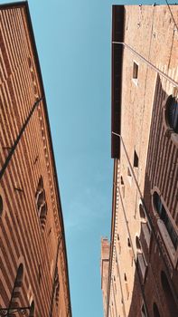 Verona, Italy-March 19, 2022: Beautifull old buildings of Verona. Typical architecture of the medieval period. Aerial view to the city with blue sky in the background. Detailed photography of the old architecture.