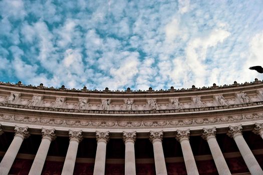 ROME, ITALY - February 05, 2022: Panoramic view around the Colosseum in city of Rome, Italy. Cold and gray sky in the background. Macro photography of the green parks with the old buildings.