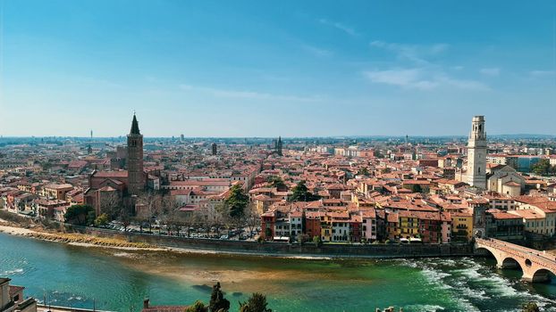 Verona, Italy - March 19, 2022: Aerial view of Verona historical city centre, Ponte Pietra bridge across Adige river, Verona Cathedral, Duomo di Verona, red tiled roofs, Veneto Region, Italy.