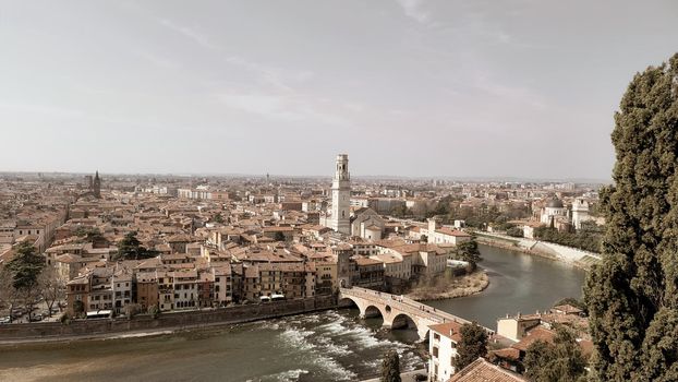 Verona, Italy - March 19, 2022: Aerial view of Verona historical city centre, Ponte Pietra bridge across Adige river, Verona Cathedral, Duomo di Verona, red tiled roofs, Veneto Region, Italy.