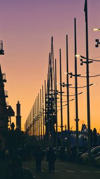 Genova, Italy - May 07, 2022: Panoramic view from the sea to the old town, and the port with beautiful sunset. Genoa bay, harbor, yacht at the pier.tourist destinations.