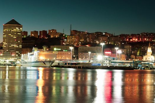 Genova, Italy - May 07, 2022: Panoramic view from the sea to the old town, and the port with beautiful sunset. Genoa bay, harbor, yacht at the pier.tourist destinations.