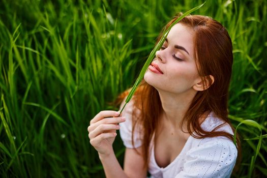 happy woman on vacation sitting in tall grass. High quality photo