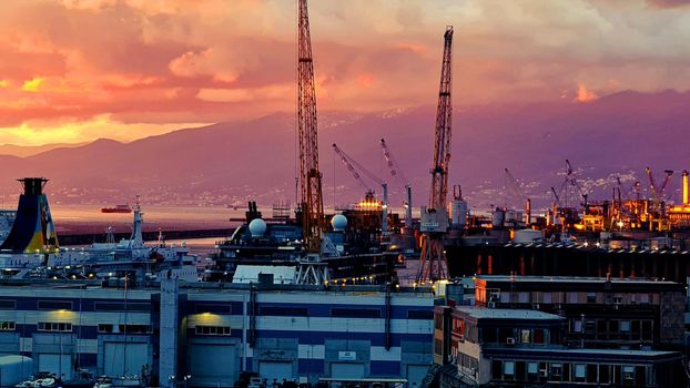 Genova, Italy - May 07, 2022: Panoramic view from the sea to the old town, and the port with beautiful sunset. Genoa bay, harbor, yacht at the pier.tourist destinations.