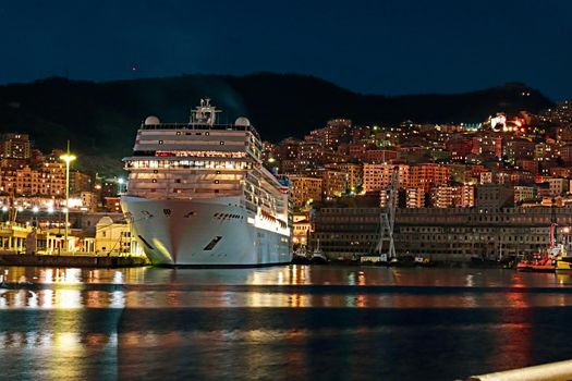 Genova, Italy - May 07, 2022: Panoramic view from the sea to the old town, and the port with beautiful sunset. Genoa bay, harbor, yacht at the pier.tourist destinations.