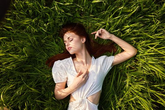 woman with her hands under4 the head lying on the grass. High quality photo