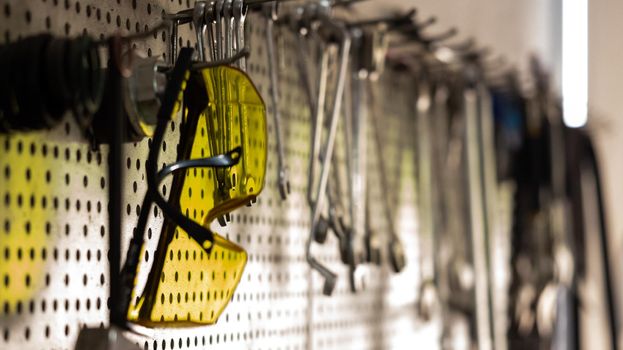 Goggles, various tools hanging on garage wall