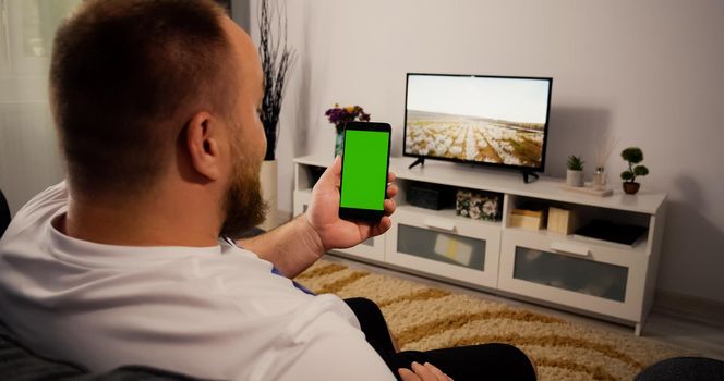 Man talking with friend in a Video Call Smartphone Green screen and Chroma Key. Mock Up with Tracking Markers and Alpha Matte. Home Video Call Concept.