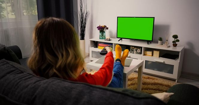 Green Screen Chroma Key Television. Woman watching Tv resting in the evening.