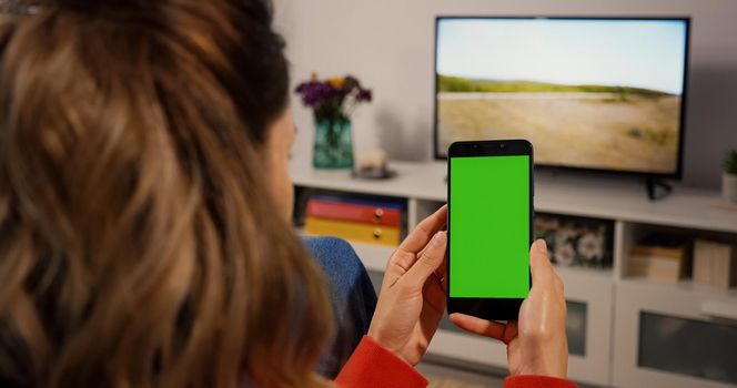 Woman hand Holding a Green Screen for Copy Space Close up Chroma Key Mockup Smartphone technology cell phone scroll and touch display Close up.