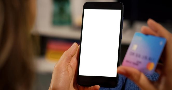 Woman Customer hands holding Credit Card and Smartphone with White Screen. Close up view. Online Payment Concept.