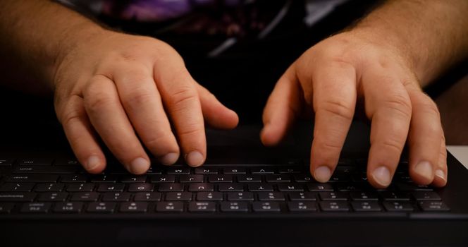 Man hands typing on laptop keyboard. Close up human hands on keyboard Front view.