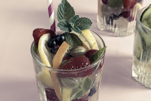 Summer refreshing cocktail of natural fruits and various berries with ice and mint leaves infused with water. Contains lemon, orange, strawberry, cherry, currant.