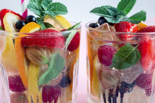 Summer refreshing cocktail of natural fruits and various berries with ice and mint leaves infused with water. Contains lemon, orange, strawberry, cherry, currant.